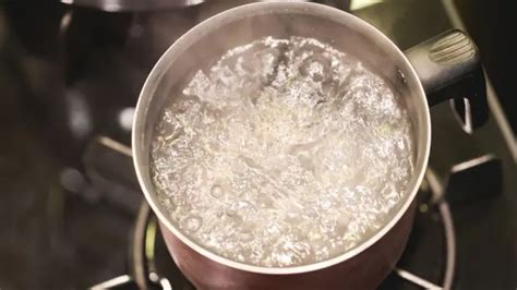 Olla con agua y cal, y rodajas de camote sumergidas