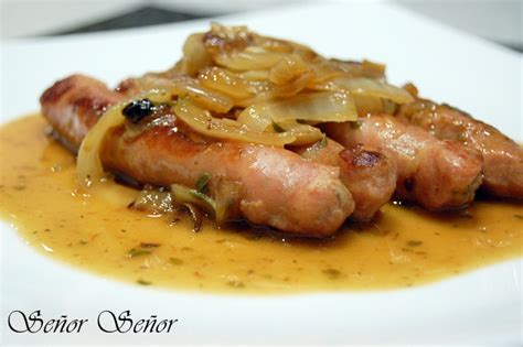 Plato de salchichas blancas y frescas con cebolla pochada en salsa de vino blanco