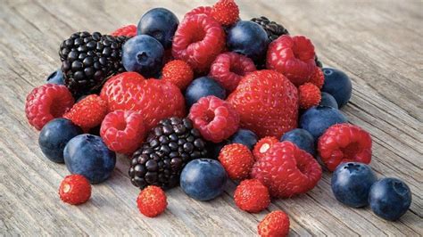 Un plato variado de frutos rojos como arándanos, frambuesas y fresas, que simbolizan los antioxidantes