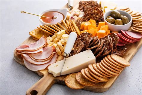 variedad de panes y galletas en una tabla de carnes y quesos