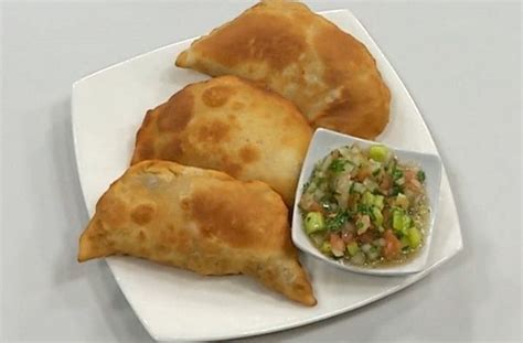 Fotografía de una empanada de cochayuyo dorada y crujiente sobre un plato de greda.