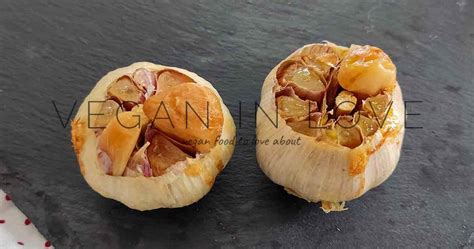 Fotografía de cabezas de ajo asadas al horno con aceite de oliva, mostrando su textura suave y dorada.