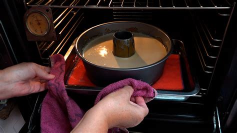 Molde con bizcoflan dentro de una bandeja de horno con agua para baño maría.