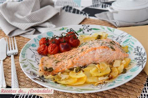 Plato de salmón al horno con cama de hortalizas variadas (pimientos, cebolla, tomate, patatas).