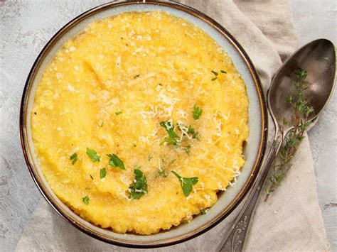 olla con polenta espesa siendo batida, con ingredientes como queso y mantequilla cerca