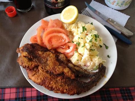 Pescado frito servido con papas mayo chilenas y una ensalada fresca