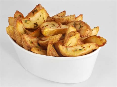Papas gajo recién fritas y enfriándose sobre papel absorbente