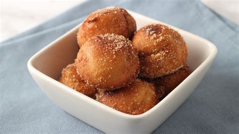 Imagen de buñuelos de banana dorados y esponjosos siendo retirados del aceite