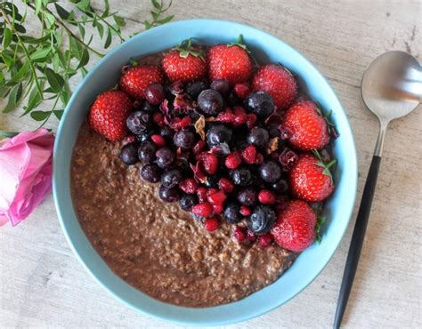 Fotografía de un bol con gachas de avena y chocolate cremosas, decoradas con frutas y semillas.
