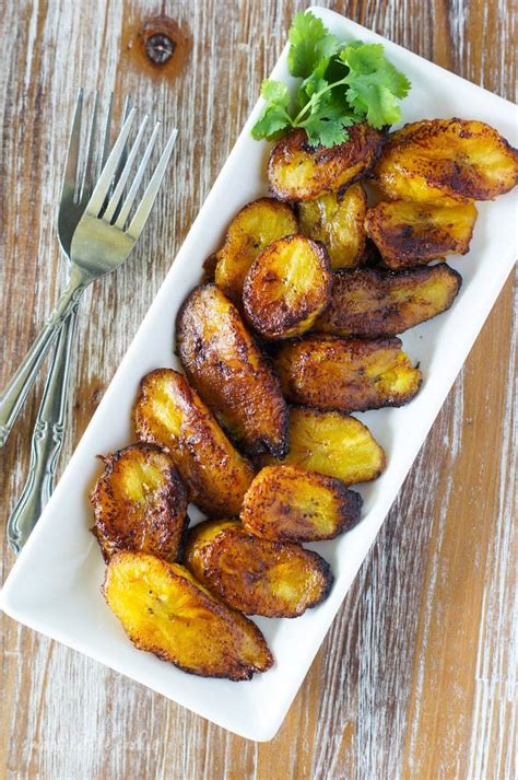 Plátanos fritos dorados y caramelizados en un plato con papel absorbente.