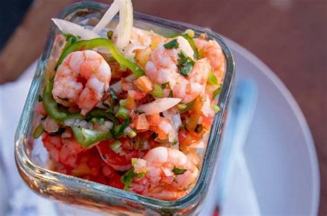 Primer plano de los ingredientes frescos para el cóctel de camarones: camarones, limón, perejil