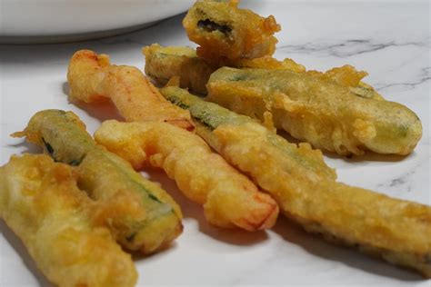 Tempura de verduras recién hecha escurriendo sobre una rejilla