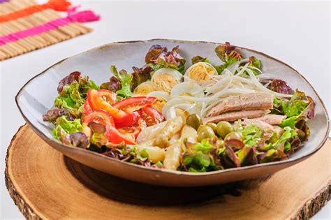 Plato final de ensalada mixta, presentada de forma atractiva con todos los ingredientes distribuidos.