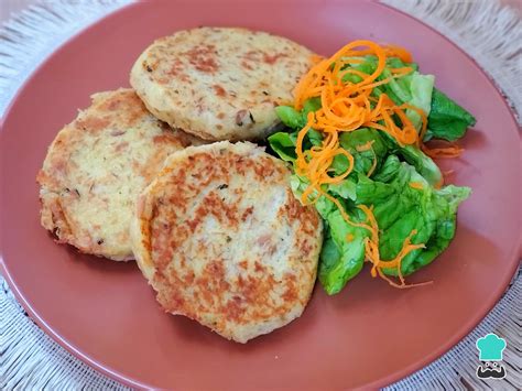 Plato terminado de tortitas de papa con camarones servido con una guarnición de ensalada fresca