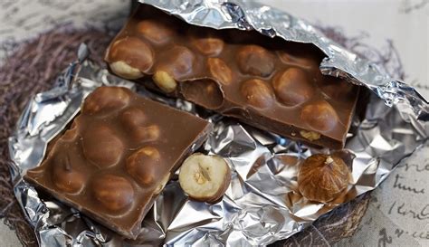 Primer plano de una barra de chocolate con avellanas enteras incrustadas