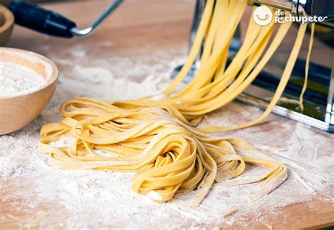 Foto de pasta fresca casera estirándose en una máquina o a mano