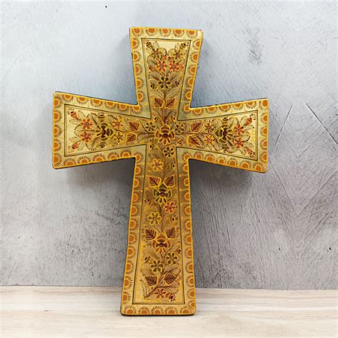 Cruz de madera con motivos florales y figura de Cristo