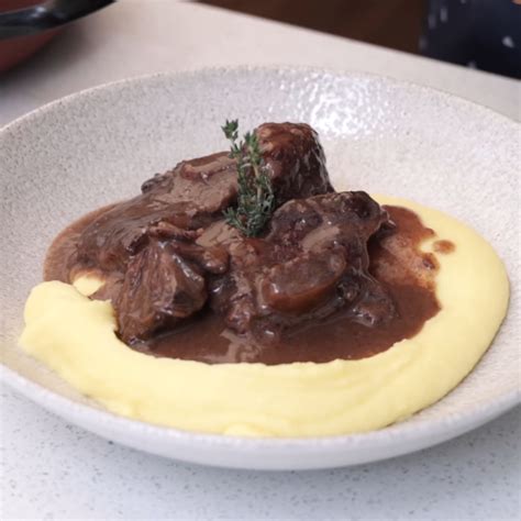 Imagen de un plato de costilla al vino con puré casero, presentado de forma apetitosa.