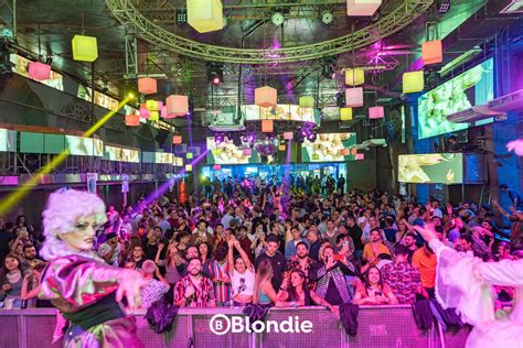 Fotografía del exterior de la discoteca Blondie de noche, con luces y gente en los alrededores, con un ambiente que evoque el lugar del incidente.