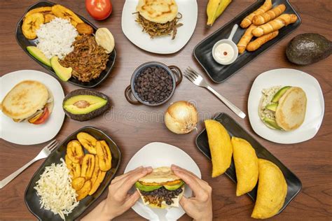 Mesa con diversos platos de comida venezolana y un tazón de guasacaca