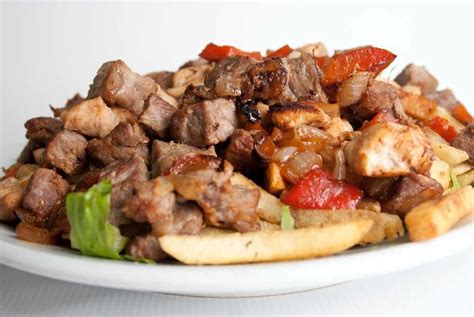 Plato de carnes a la parrilla con un tazón de guasacaca para acompañar