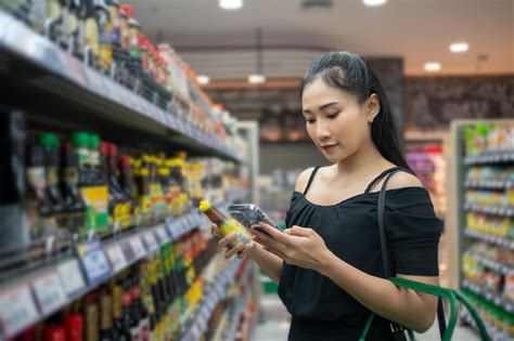 Persona leyendo una etiqueta de un producto cosmético, con lupa y un fondo de ingredientes naturales