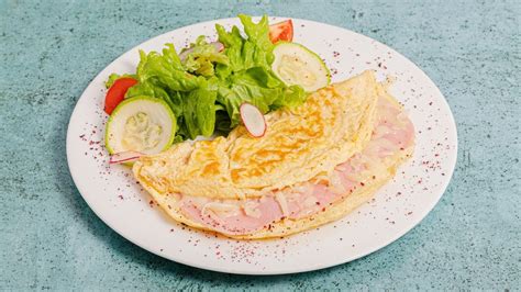 Omelette de jamón y queso esponjoso recién hecho en una taza, saliendo del microondas