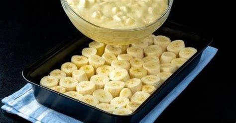 Ilustración de los ingredientes necesarios para el postre de banana, incluyendo leche, leche condensada, maicena, galletas de vainilla y bananos.