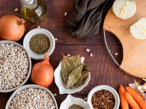 Una variedad de ingredientes básicos de cocina como harina, sal, huevos, agua y leche dispuestos sobre una tabla de madera
