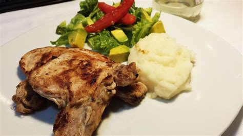 Plato de chuleta de cerdo jugosa con guarnición de puré de papas y ensalada