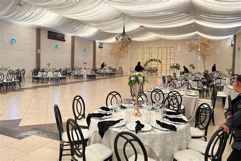 Fotografía profesional de un salón de eventos con arquitectura moderna y vigas a la vista, preparado para una celebración de alto nivel.