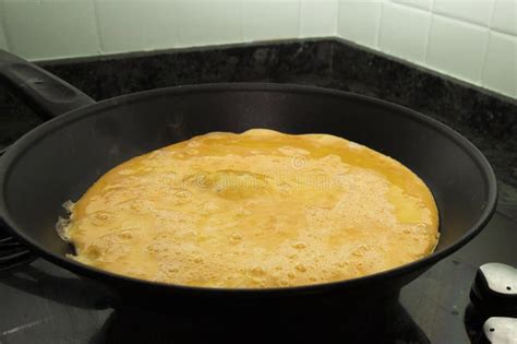 Proceso de cocción de la tortilla en sartén antiadherente, mostrando los bordes cuajados