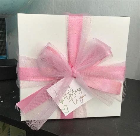 Caja de regalo decorada, llena de diversas galletas y dulces navideños.