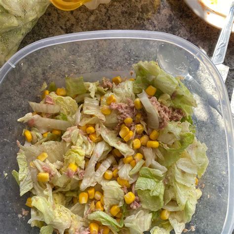 Fotografía de una ensalada fresca compuesta por lechuga, granos de maíz amarillo y atún en un tazón saludable
