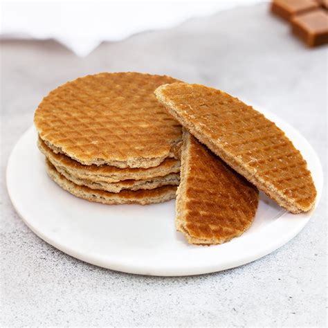 Photo of finished stroopwafels, some whole and some cut showing the caramel filling