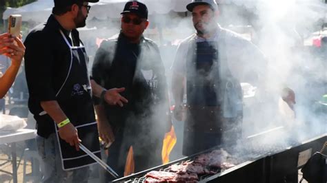 Persona asando carne bajo un toldo o protección durante un día lluvioso con ambiente acogedor