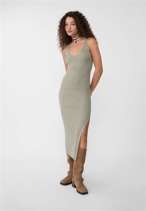 Maniquí femenino vistiendo un vestido de punto de tartán rojo y negro con botas altas.