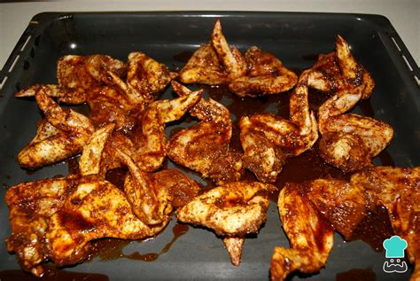 Alitas de pollo adobadas en una bandeja de horno, listas para hornear