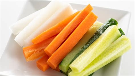 Primer plano de verduras cortadas en bastones y láminas uniformes