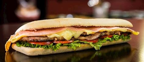 Ilustración de un sandwich de lomo abierto, mostrando las capas de carne, queso, jamón, huevo frito, tomate y lechuga.
