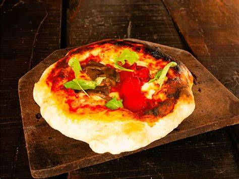 Detalle de la pizza estilo porteño con abundante mozzarella y masa gruesa