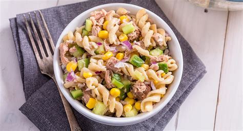 Plato de pasta servido con salsa cremosa de atún y decorado con hierbas frescas