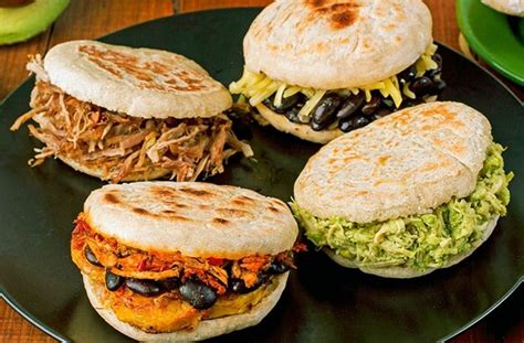 Variedad de arepas frescas disponibles en un mercado callejero latinoamericano