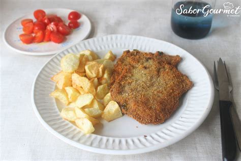 Plato de filetes empanados servidos con una salsa rica y guarnición de patatas