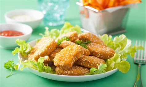 Plato terminado de nuggets veganos dorados acompañados de una ensalada fresca