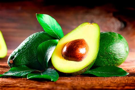 Imagen de aguacate en rodajas, un puñado de nueces y semillas de calabaza.