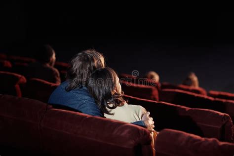 Pareja viendo una película romántica en una sala de cine privada