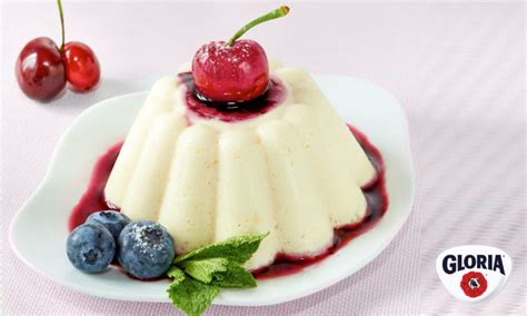 Foto detallada de un esponjado de yogur y limón desmoldado, decorado con una rodaja de limón y una hoja de menta fresca.