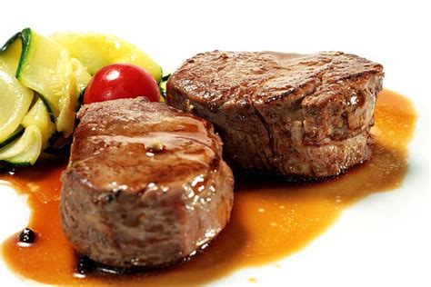 Plato elegante de medallones de res rellenos de camarones servido con guarnición