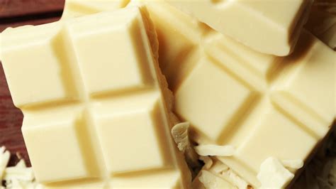 Imagen de un chocolate blanco de alta calidad en tableta y troceado.